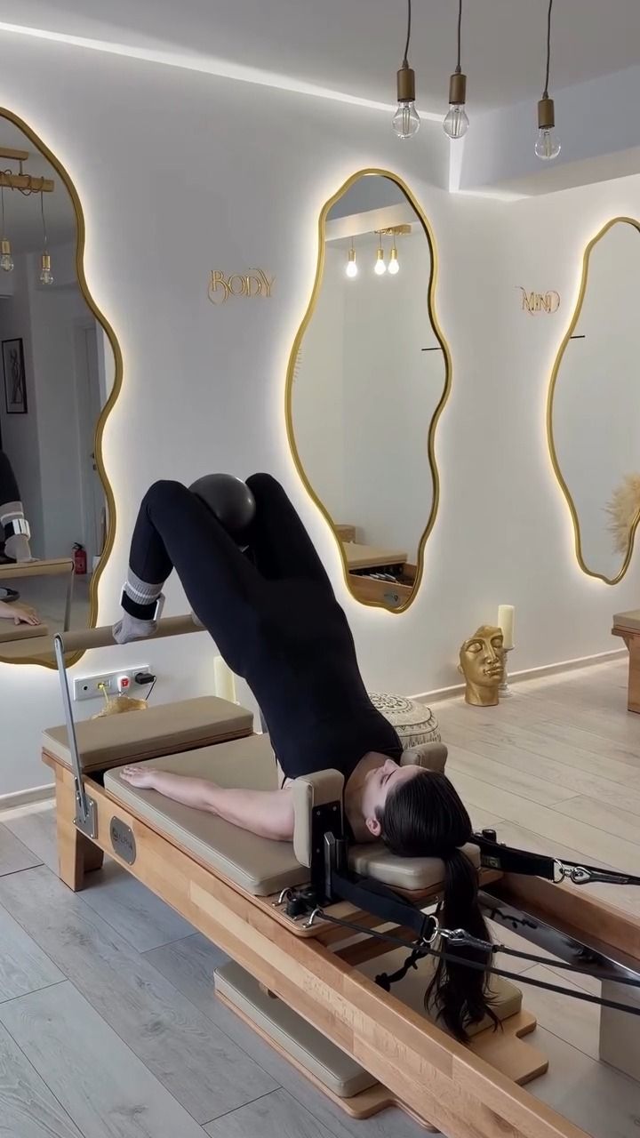 Exercițiu pe reformer în fața oglinzilor ondulate, luminate